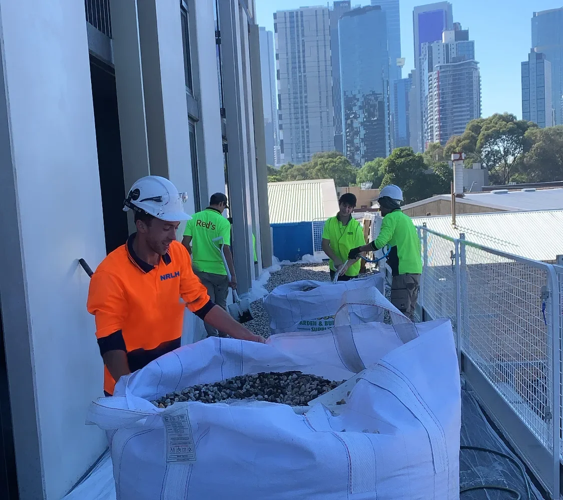 An NRLH labourer working at bulk bags, with other workers behind him